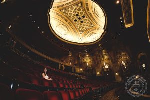 Sheas senior portraits on the seats in the theater gold ceiling by portrait pretty photography