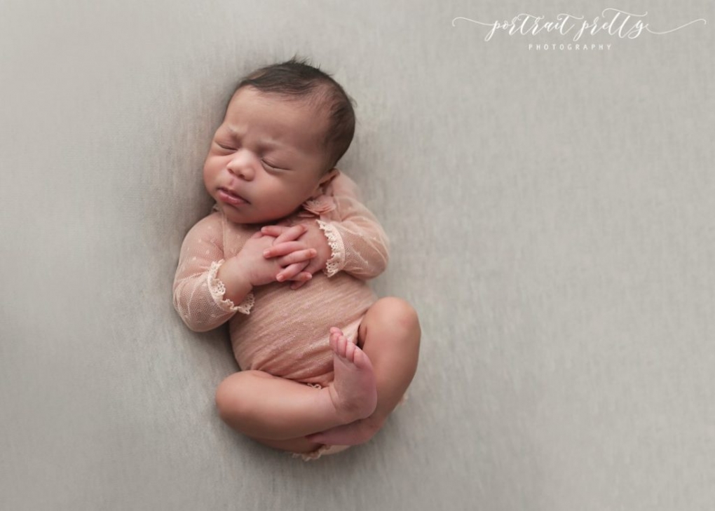 buffalo ny baby photographer newborn laying on backdrop with hands interlocked, newborn photography inspiration